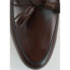 A Berwick 1 707 dark brown leather Belgian loafer with a braided leather bow tie and tassel adornment.