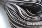 A close-up image of a waxed round brown shoe lace.