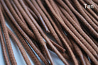 A close-up image of a waxed round brown shoe lace.