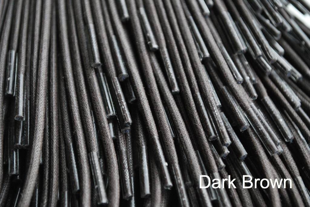 A close-up of a dark brown waxed round cotton shoe lace.