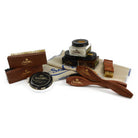 An assortment of shoe care products from Saphir Medaille D'Or including polishing cloths, brushes, cream polishes in black and medium brown, a shoe bag and a neutral wax polish.