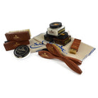 An assortment of shoe care products from Saphir Medaille D'Or including polishing cloths, brushes, cream polishes in black and medium brown, a shoe bag and a neutral wax polish.