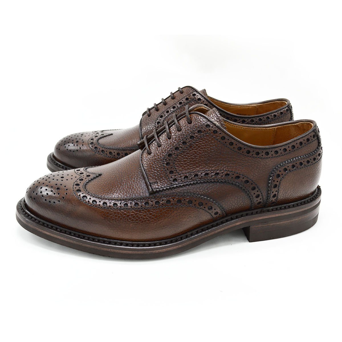 A Berwick 1707 brown brogue derby shoe with a round toe shape and lace-up closure. It features a grainy texture and brogue detailing & Dainite soles