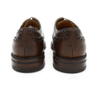 A Berwick 1707 brown brogue derby shoe with a round toe shape and lace-up closure. It features a grainy texture and brogue detailing & Dainite soles