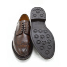 A Berwick 1707 brown brogue derby shoe with a round toe shape and lace-up closure. It features a grainy texture and brogue detailing & Dainite soles