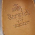 A Berwick 1707 brown brogue derby shoe with a round toe shape and lace-up closure. It features a grainy texture and brogue detailing & Dainite soles