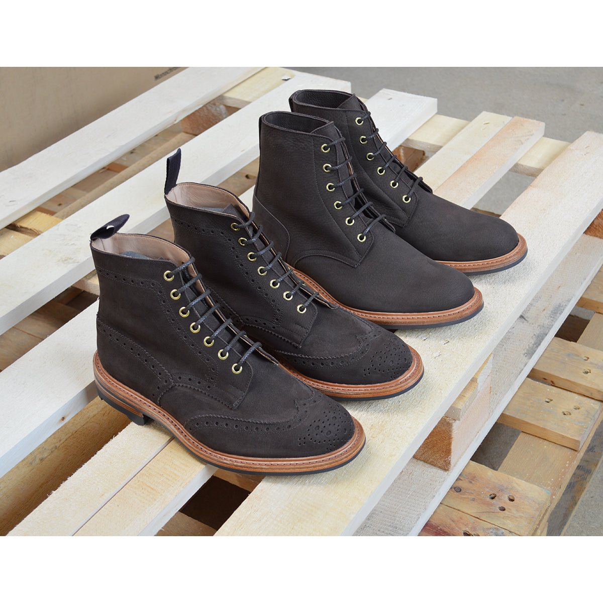 A dark brown Trickers Bernwood service boot made of Hydro Nubuck with a Dainite sole, featuring brass eyelets and a cream Barbour welt.